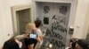 Aktivisti Inicijative mladih za ljudska prava čiste grafite mržnje na vratima NVO Žene u crnom u Beogradu, 27. oktobar 2021. godine 