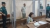 Abduqodir Muminov in the defendant's cage in a Tashkent courtroom in July