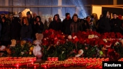“Крокус Сити Холл” борборундагы куралдуу кол салуудан каза тапкандарды эскерип жаткандар.