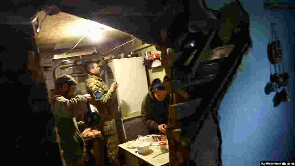 Украинские военные готовят еду в своем укрытии 