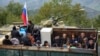 Ethnic Armenian flee Karabakh for Armenia sitting in a truck at the Lachin checkpoint controlled by Russian peackeepers and Azeri border guards, September 26, 2023. 