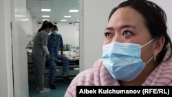 Агасына донор болуп, бир бөйрөгүн берген Атыргүл Калманбетова. Арткы фондо бөйрөгүн алмаштырган бейтап Жаныбек Калманбетовду медайым көзөмөлдөп жатат 