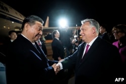 Macaristan baş naziri Viktor Orban (sağda) Budapeşt ava limanında Qıtay yolbaşçısı Si Tszinpinni qarşılay, 2024 senesi mayısnıñ 8-i