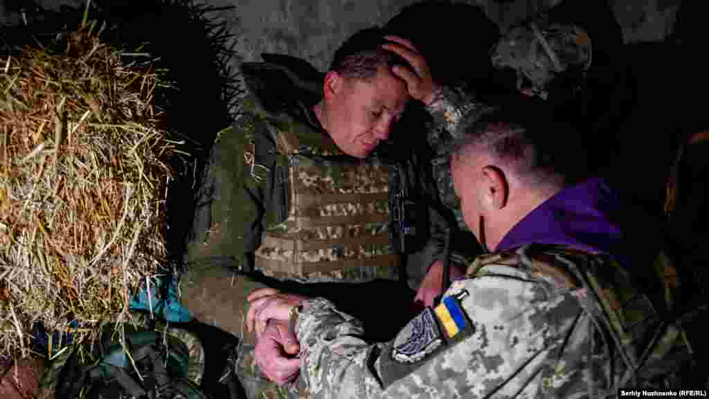 Украин армиясындагы капеллан Александр катардагы жоокер менен чогуу кудайга жалынууда, 24-апрель, 2022-жыл.