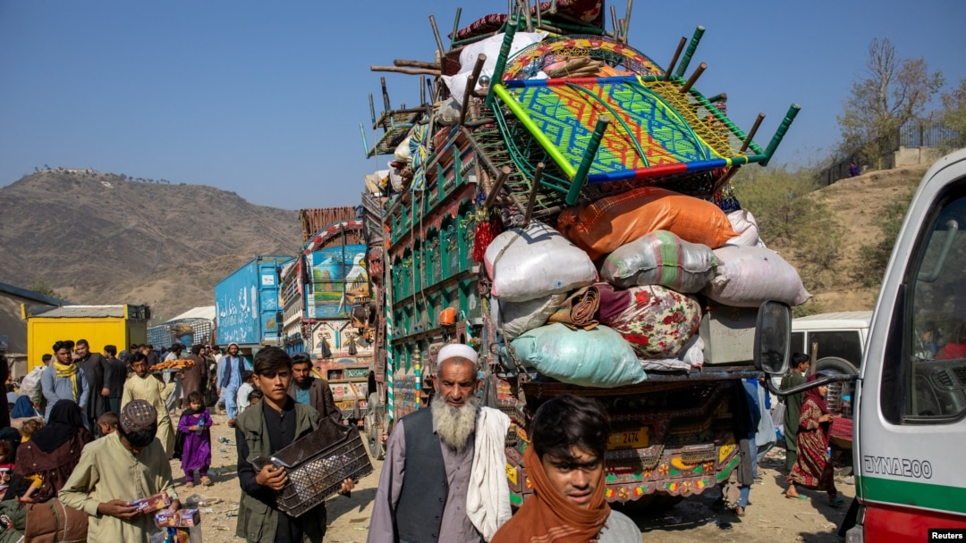 Trucks loaded with goods arrive as Afghan nationals head back to Afghanistan at the Torkham border crossing between Pakistan and Afghanistan on October 30.