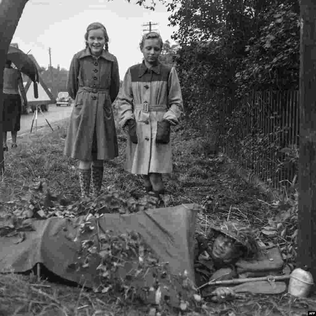 Două fete germane privesc un soldat britanic în timpul exercițiului NATO din 1951. Ideea unei alianțe militare transatlantice a apărut după cel de-al Doilea Război Mondial, când URSS părea pregătită să se impună într-o Europă epuizată. În 1948, Kremlinul a sprijinit o lovitură de stat comunistă în Cehoslovacia și a început să facă presiuni asupra Norvegiei pentru a forma un pact de „neagresiune”. 