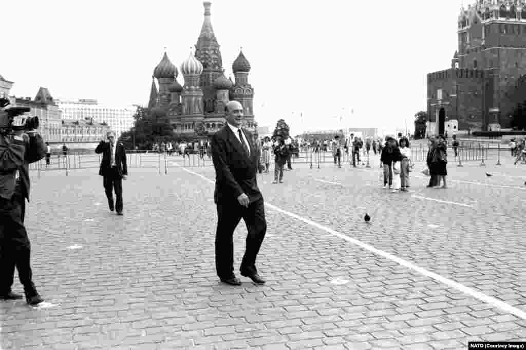 Secretarul general al NATO, Manfred Worner, traversează Piața Roșie în timpul unei vizite la Moscova în iulie 1990. Se pare că semințele unei noi rupturi între Moscova și Occident au fost semănate atunci când secretarul de stat american James Baker a declarat conducerii sovietice în februarie 1990 că, „dacă Statele Unite își mențin prezența în Germania în cadrul NATO, niciun centimetru din jurisdicția militară actuală a NATO nu se va extinde în direcția est”. Acest mesaj a fost repetat, deși nu a fost niciodată aprobat în mod oficial, de ministrul german de externe Hans-Dietrich Genscher.