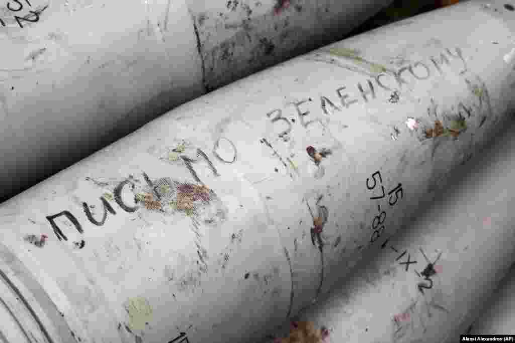 Un obuz de artilerie cu fraza „scrisoare pentru Zelenski” fotografiat într-o poziție a luptătorilor pro-ruși din regiunea Donețk din Ucraina, în octombrie 2022. Scrierea pe proiectile este un obicei vechi de cel puțin 2.000 de ani. Primul exemplu cunoscut este un proiectil antic grecesc pentru praștie, făcut din plumb și pe care scrie cu cuvântul „prinde!”. 