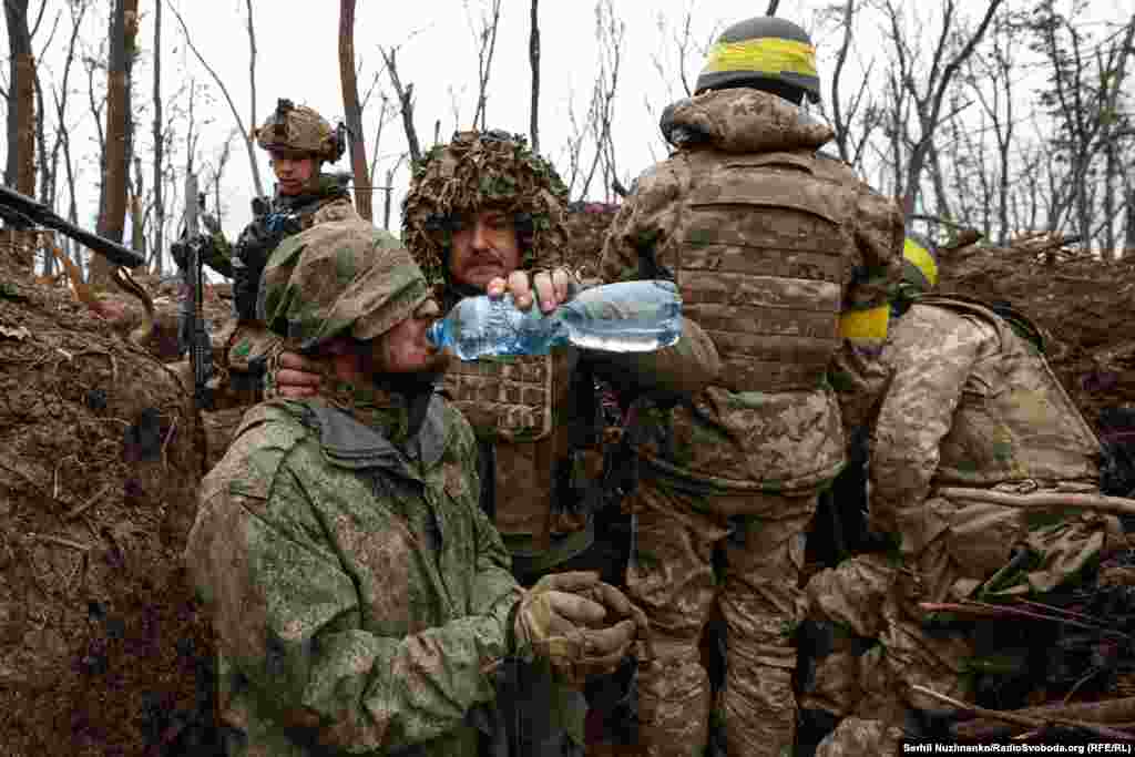 Взятому в плен российскому солдату дают попить воды из бутылки. Окрестности Бахмута, май 2023 года
