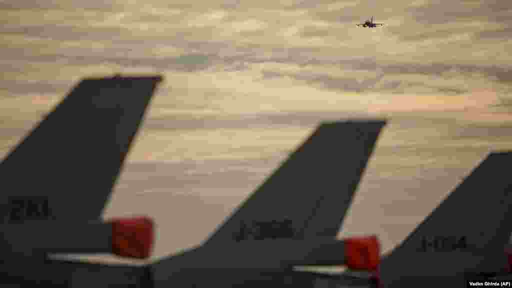 A Román Légierő F–16-os vadászgépe repül a légibázis felett. Románia, amely 2004 óta NATO-tag, növelte védelmi kiadásait, miközben a NATO megerősítette jelenlétét Európa keleti szárnyán azzal, hogy további többnemzetiségű harccsoportokat küldött a szövetség tagállamaiba, Romániába, Magyarországra, Bulgáriába és Szlovákiába