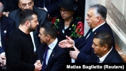 Ukrainian President Volodymyr Zelenskiy (left) talks with Viktor Orban at the inauguration of new Argentinian President Javier Milei in Buenos Aires on December 10. The Hungarian prime minister is seen as the main stumbling block to Kyiv getting the green light this week to start EU accession talks.
