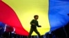 A boy plays underneath a giant national flag during an electoral rally supporting presidential candidate Nicusor Dan in Bucharest on May 11.