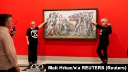 Klimatski demonstranti iz Extinction Rebellion-a zalijepili su se za Picassov "Masakr u Koreji" u NGV-u u Melburnu, Australija 9. oktobra 2022. 