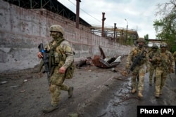 Ruski vojnici 18. maja patroliraju uništenim dijelom Metalurškog kombinata Željezara i čeličana Ilič u Mariupolju, na teritoriji pod vlašću proruskih separatista u istočnoj Ukrajini, tokom putovanja u organizaciji ruskog Ministarstva odbrane.