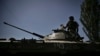 Украински войник стои върху брониран автомобил, движещ се към линията на фронта в град Лисичанск в района на Донбас в Източна Украйна на 9 юни 2022 г.