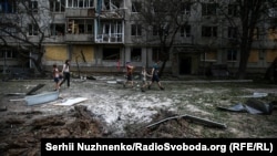 Grupa dece prolaze pored ruševina posle ruskog raketnog udara u gradu Bahmutu na 55 kilometara jugozapadno od Lisičanska i Sjeverodonjecka gde se vode žestoke bitke, 13. jun 2022.