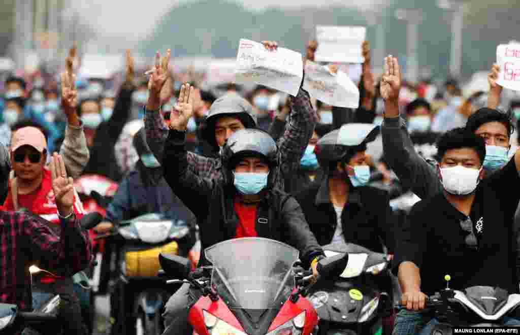 Demonstruesit që ngasin motoçikleta bëjnë përshëndetjen me tre gishta, një simbol i rezistencës dhe mbajnë parulla ku shkruhet 'Lironi Aung San Suu Kyi' gjatë një proteste kundër grushtit të shtetit në Naypyitaw, 7 shkurt, 2021. (EPA-EFE/MAUNG LONLAN)