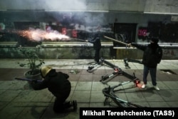 Activists shoot fireworks at riot police near the Georgian parliament on December 7, 2024.