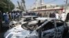 Pakistani security personnel stand next to burned-out vehicles in front of the Chinese Consulate after an attack in Karachi on November 23.