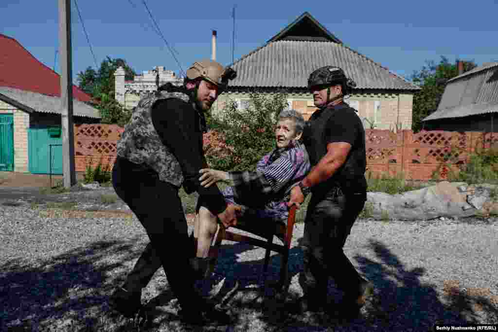 Эвакуация жительница Новогродовки в Донецкой области, август 2024 года. Через 20 дней российские войска оккупировали город. Мужчина справа &mdash; Оуэн, доброволец из Новой Зеландии. Бывший военный медик, он приехал в Украину, чтобы помогать спасать людей&nbsp;