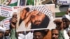 Indian Muslims hold a scratched photo of Jaish-e Mohammad group chief, Maulana Masood Azhar, as they shout slogans against Pakistan during a protest in Mumbai on February 15.