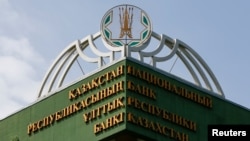 Алматыдағы Ұлттық банк ғимаратындағы жазу мен эмблема.