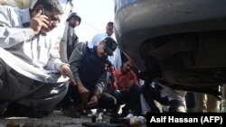 Pakistani investigators look at the belongings of attackers including grenades outside the Chinese consulate after an attack in Karachi on November 23.