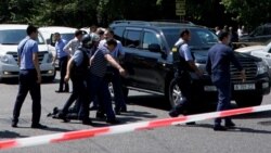Алматы орталығында шабуылға ұшыраған полицейді көтеріп бара жатқан адамдар. 18 шілде 2016 жыл.