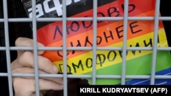 Гей-активист держит плакат с надписью: Любовь сильнее гомофобии. Москва, 25 мая 2013 года.