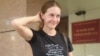 Журналистката Светлана Прокопиева пред съдебната зала. На фанелката й пише "Няма да замълчим".