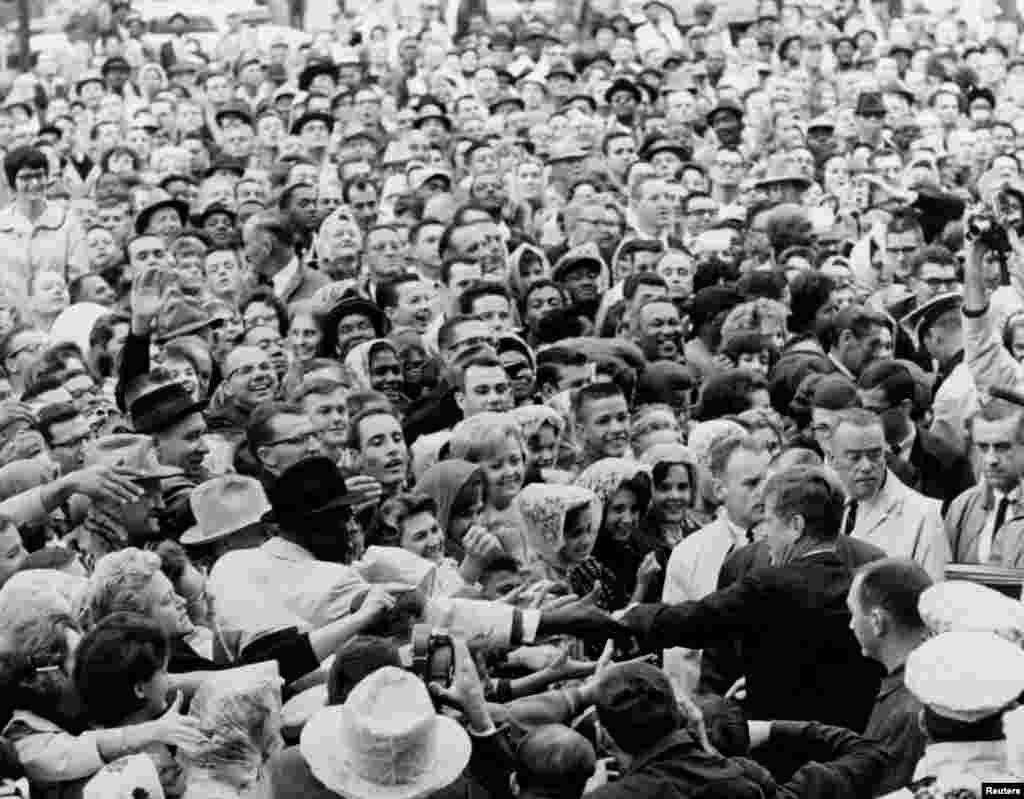 Presidenti John F. Kennedy përshëndet turmën e mbledhur në tubimin politik në Fort Worth, Texas. 