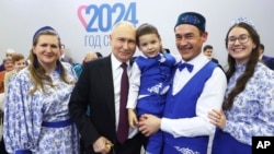 Владимир Путин (байн) дар як маъракаи бахшида соли оила дар Русия. Маскав, соли 2024