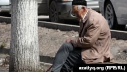 Көшеде демалып отырған қарт адам. (Көрнекі сурет)