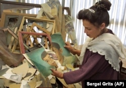 Iunie 2002. Sabera Rahmani, director al Muzeului Național al Afganistanului, arată una dintre cele mai mult de 400 de picturi distruse de către talibani în timpul primei lor guvernări, care a durat șase ani.