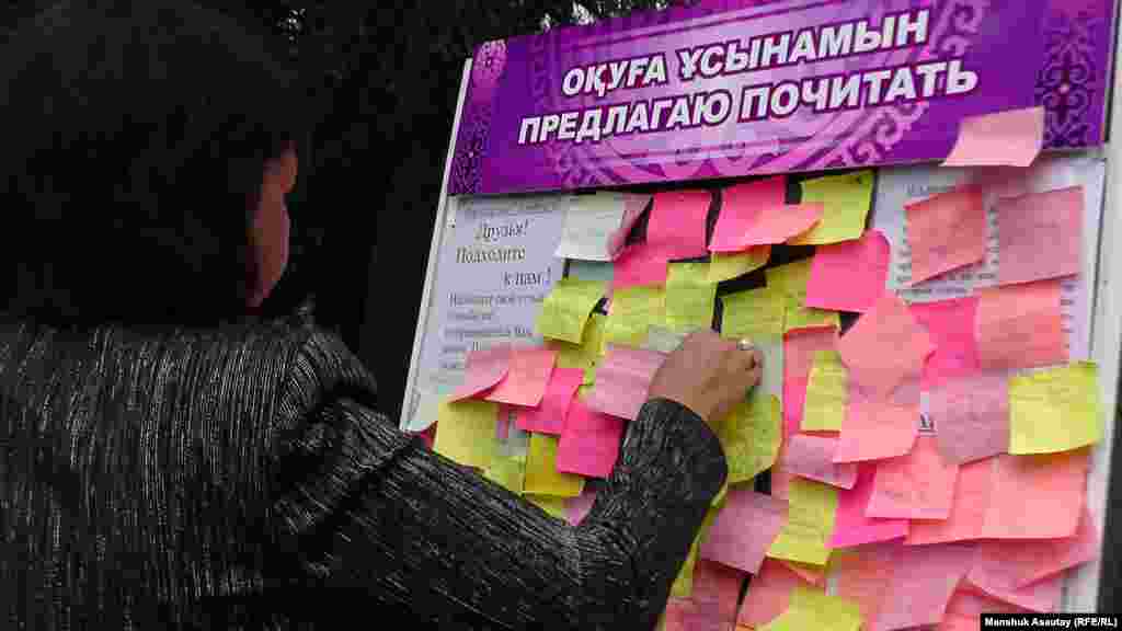 Посетительница оставляет пожелания на доске с рекомендациями. 
