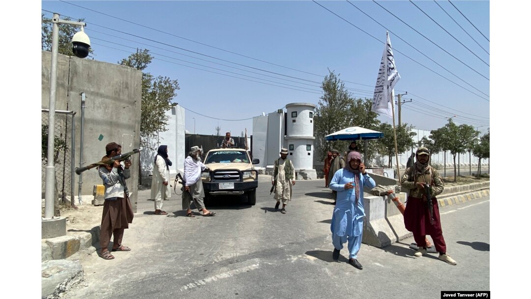 Taliban fighters stand guard at an entrance gate outside the Interior Ministry in Kabul on August 17. The armed militants are a common sight in the capital.
