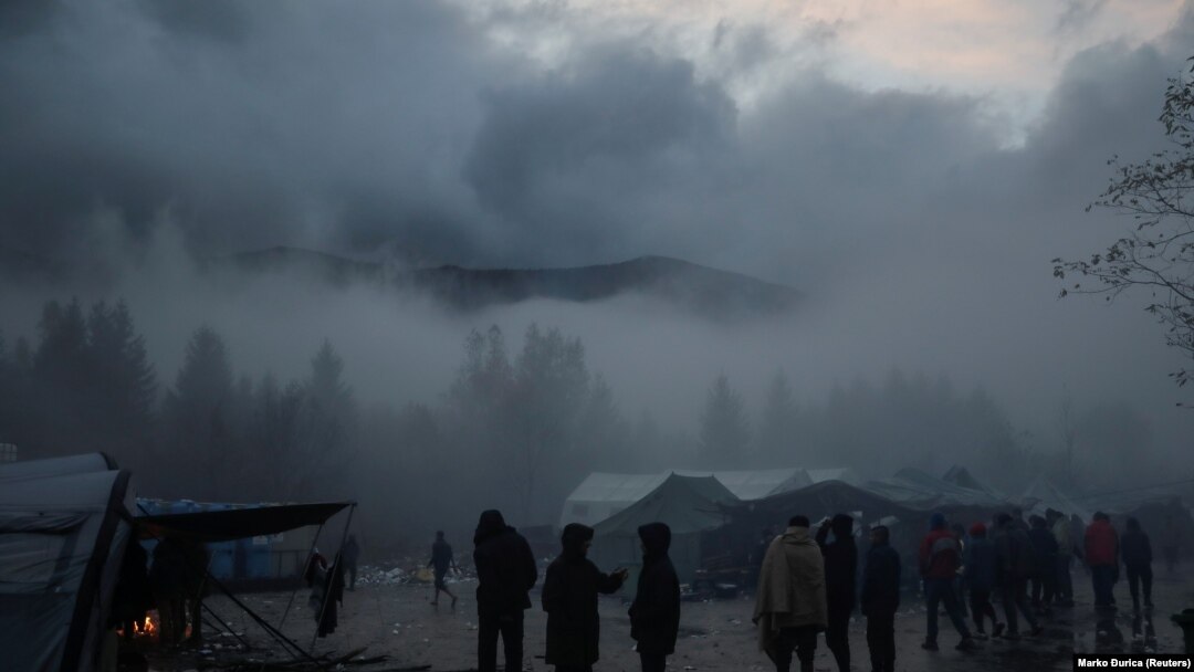 Migrants stand in fog inside Vucjak camp near Bihac