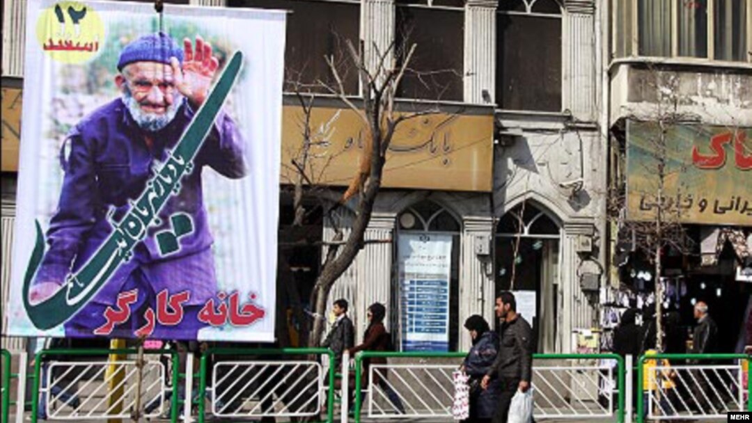 People walk past a billboard in Tehran for the upcoming parliamentary elections in Iran on March 2.