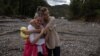 Two local woman react after floods and landslides hit the village of Trusina in Bosnia-Herzegovina. 