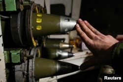 Ukrajinski vojnik pokazuje granate kalibra 155 mm unutar samohodne haubice blizu grada Bahmuta na prvoj liniji fronta.