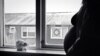 Pregnant woman standing by window