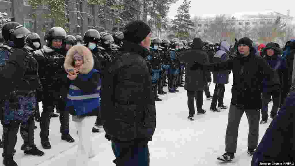 Ақтөбе әкімдігі алдында тұрған полиция мен демонстранттар. 5 қаңтар 2022 ж.