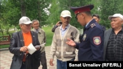 Жители Уральска во время несанкционированной акции на аллее памяти жертв политических репрессий: слева направо Максат Айсаутов, Махсот Кубеев, Альбек Ергазиев, сотрудник полиции и Искак Азбергенев. Уральск, 31 мая 2018 года.