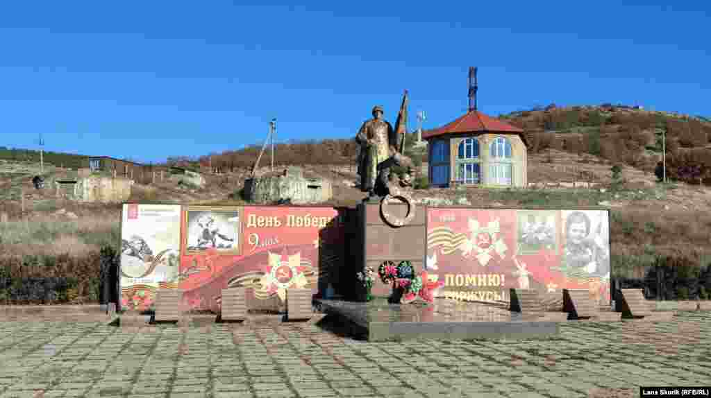 Меморіал на братській могилі воїнів і жителів села, які загинули у Другій світовій війні, на задньому плані ліворуч від пам'ятника – спорудження двох бетонних ДОТів