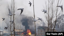 Flames and smoke billow from a residential building where militants are suspected to have taken refuge during a gun battle in Pulwama, south of Srinagar in Indian-controlled Kashmir on February 18.