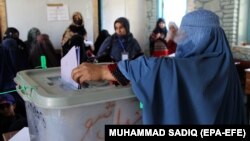 An Afghan woman casts her vote during parliamentary elections in Kandahar on October 27.