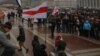 Ніна Багінская стаіць са сьцягам на мітынгу прадпрымальнікаў