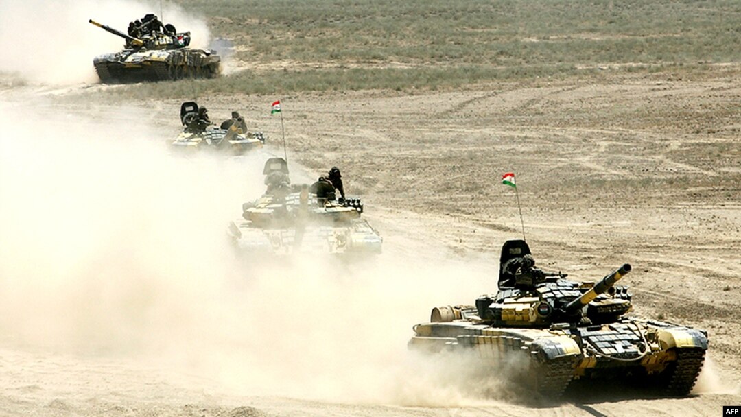 Russian-built tanks roll under Tajik flags during Peace Mission 2012 joint counterterrorism military exercises of the troops from the six countries in the Shanghai Cooperation Organization in Khujand in June 2012.