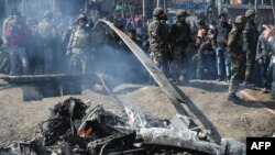 Indian soldiers and Kashmiri onlookers stand near the remains of an Indian Air Force aircraft after it crashed in Budgam district on February 27.