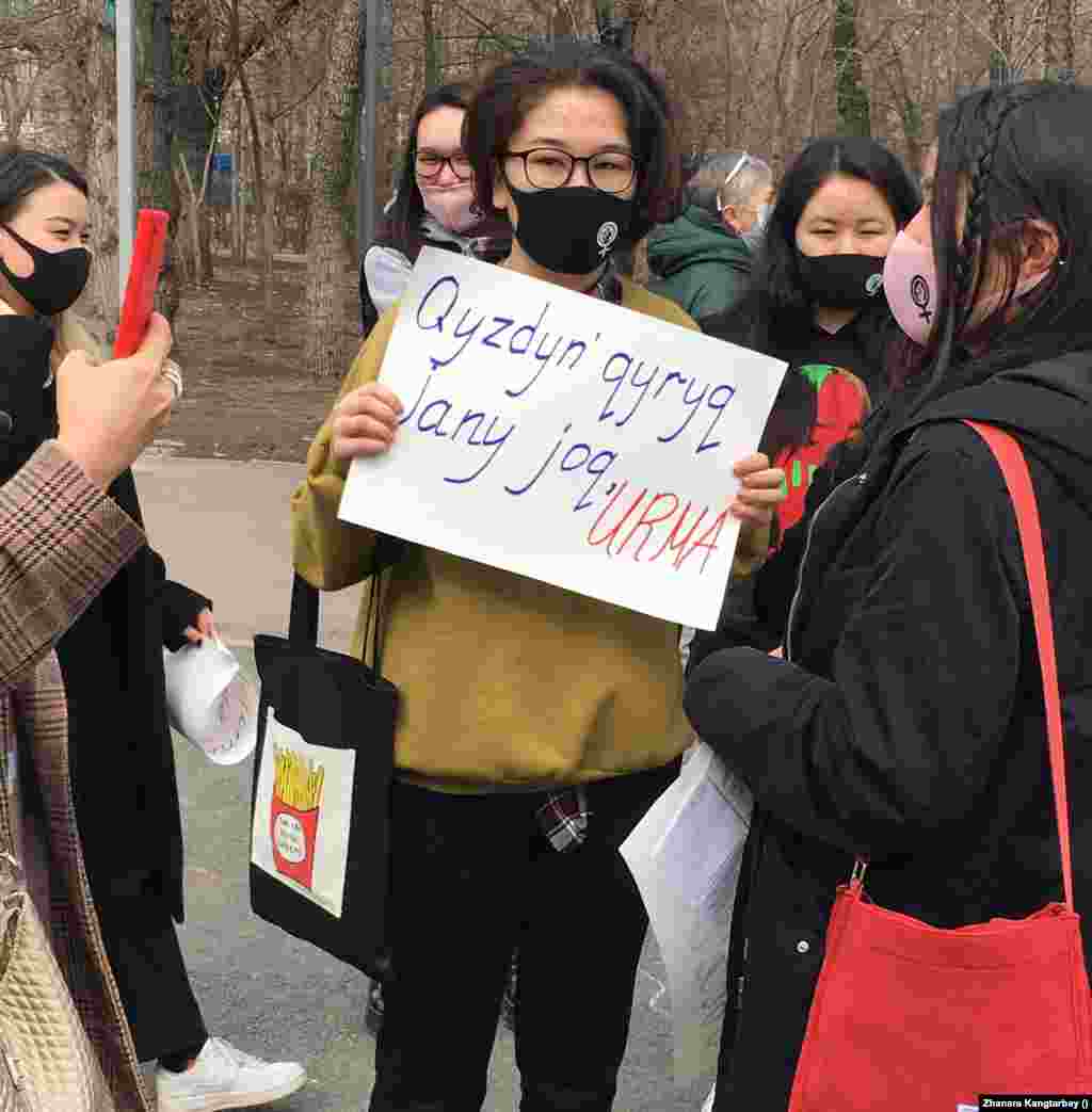 "Әйелдің қырық жаны жоқ. Ұрма" деген плакат ұстап тұрған қатысушы. 
